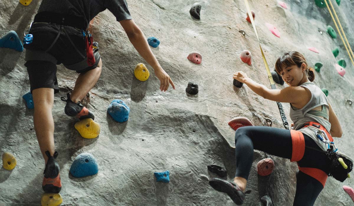 Collaborateurs surun mur d'escalade symbolisant les performances de l'entreprise