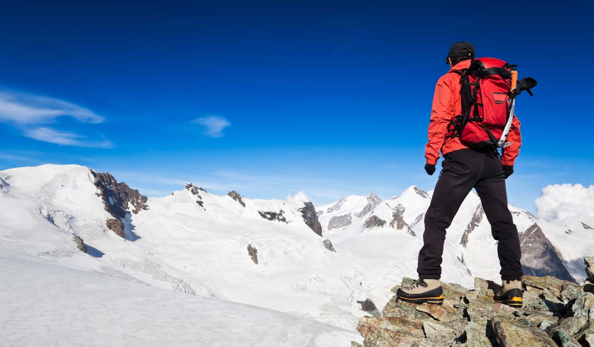 Alpiniste au sommet d'une montagne symbole de performance
