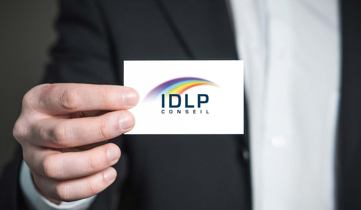 Manager tenant une carte de visite au logo d'IDLP formation à Rennes